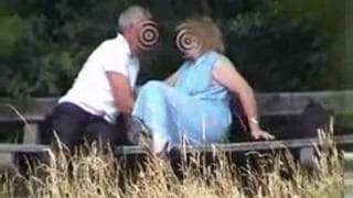 A mature couple have some fun on a bench A mature couple have some fun on a bench