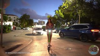She cruises around in a scooter showing her breasts in the street